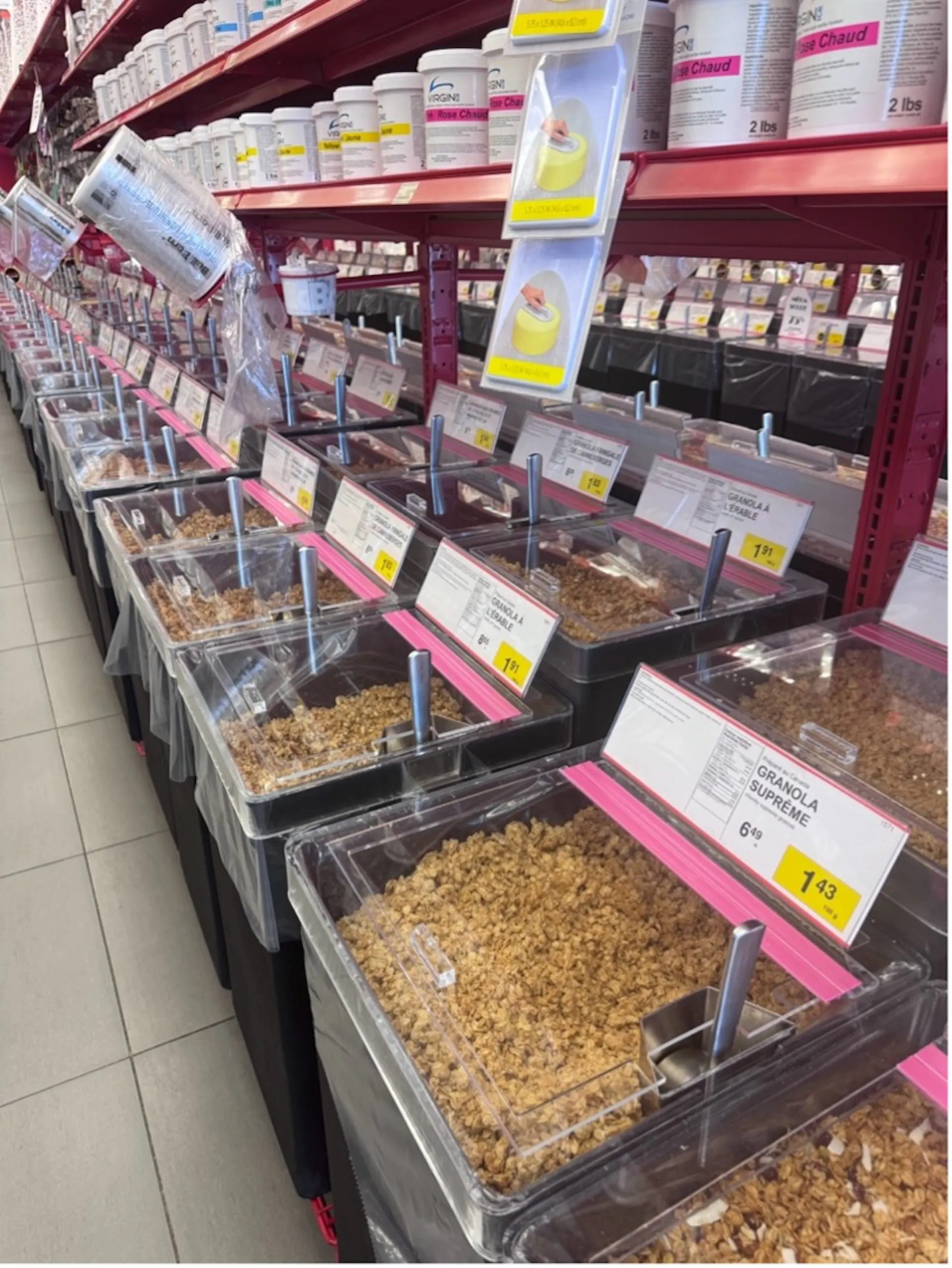 A store aisle containing several bins filled with food items, with scoops to scoop them out.