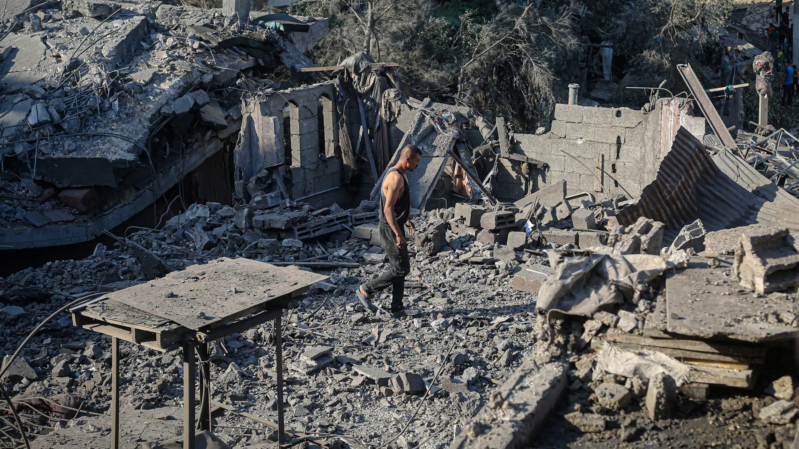 A man walks around rubble.