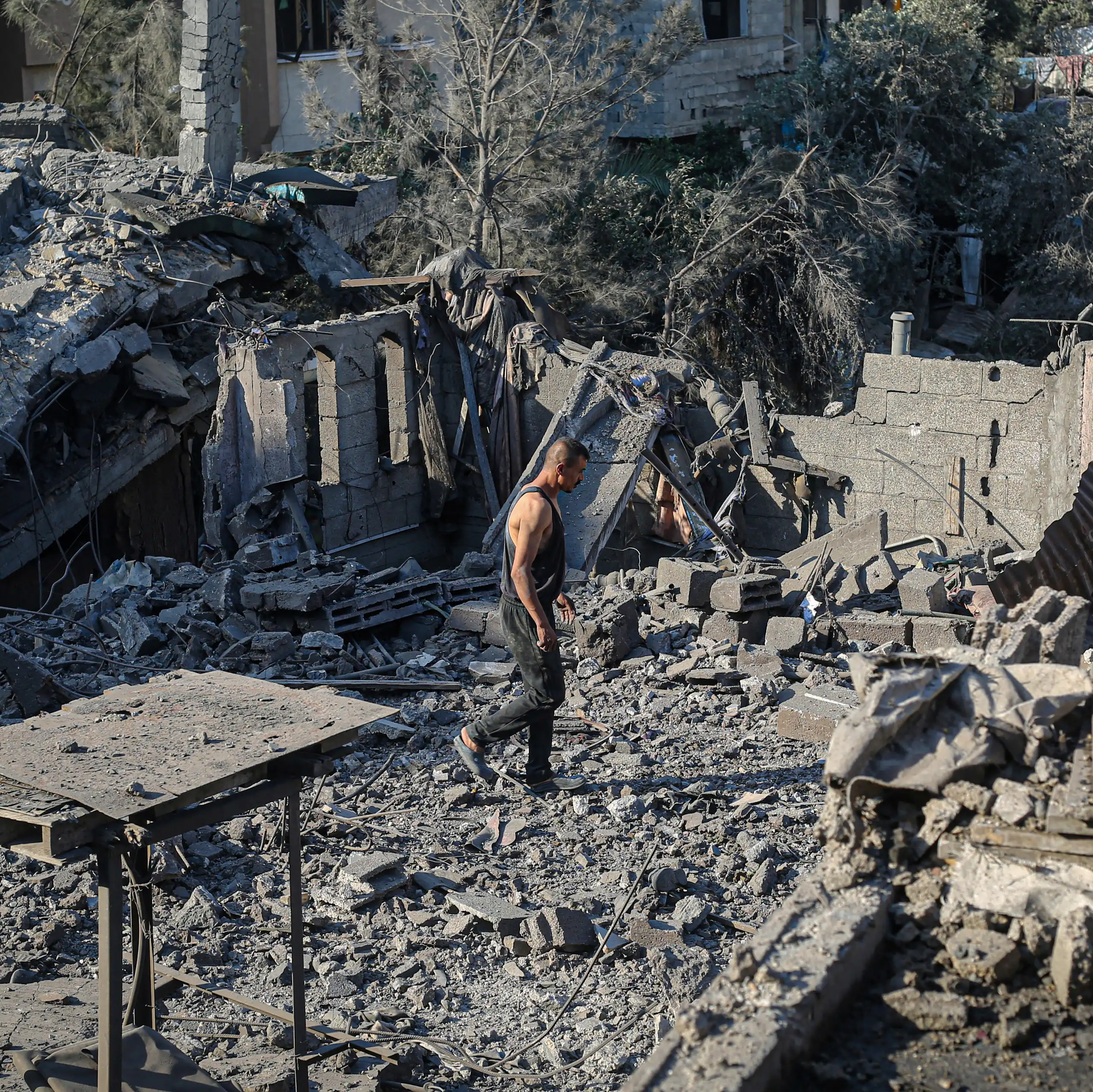 A man walks around rubble.