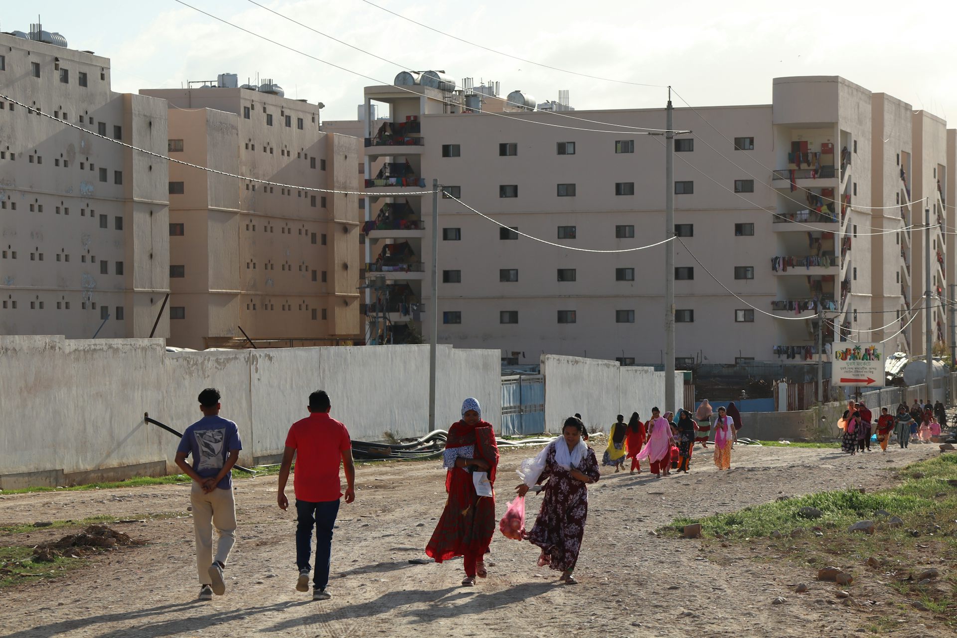 Migrant workers walk back to their dormitories in Al-Hassan industrial zone