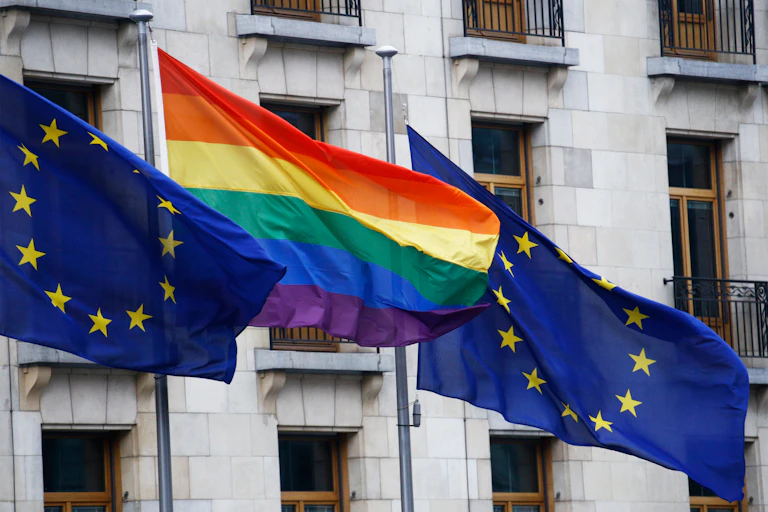 European Union and LGBT Pride flags flying at the European Council building in Brussels.