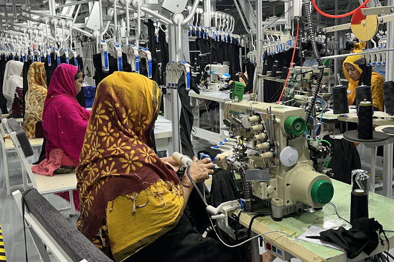 Migrant workers sewing clothes in a factory in Aqaba.