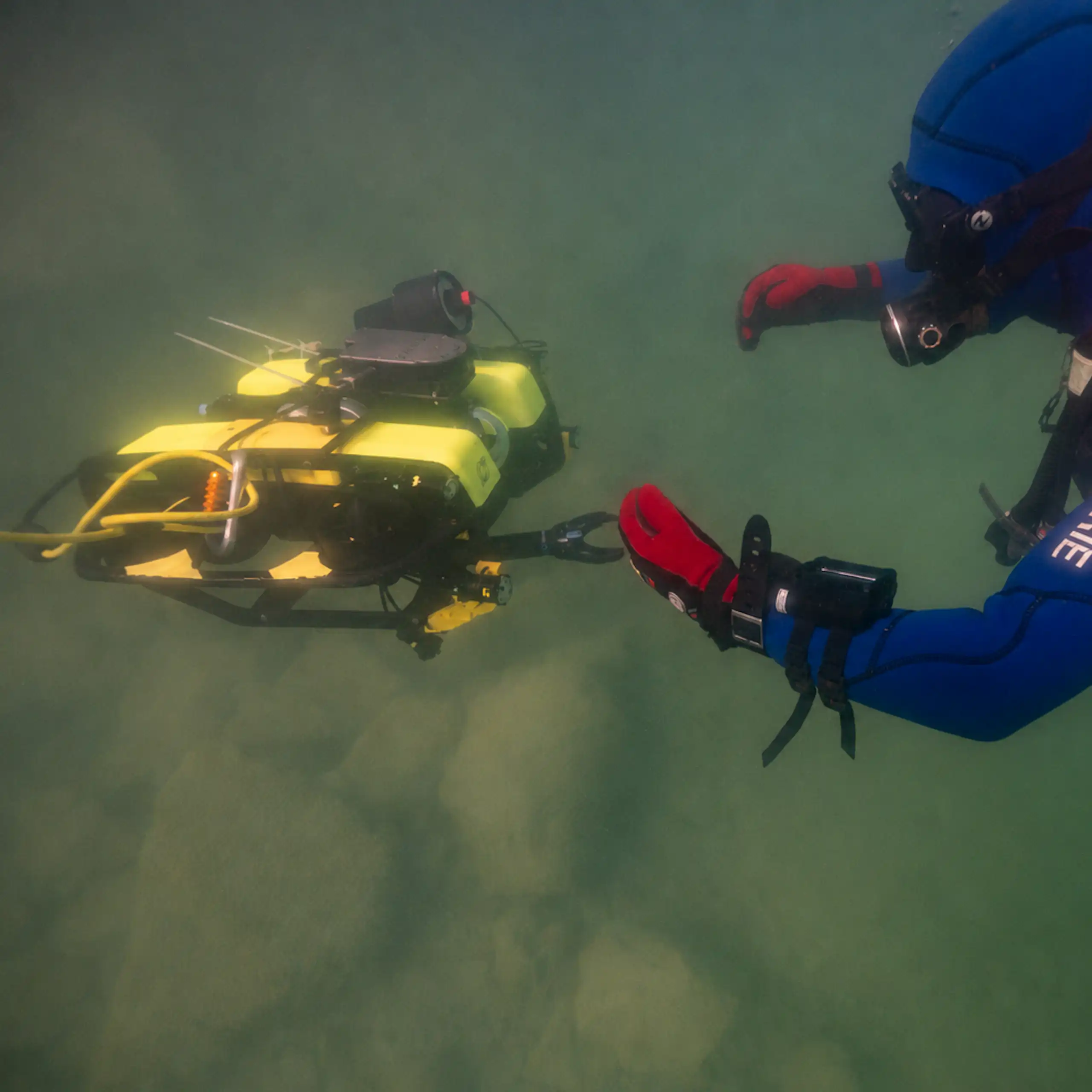 Prise de vue sous l'eau d'un agent manipulant le ROV.