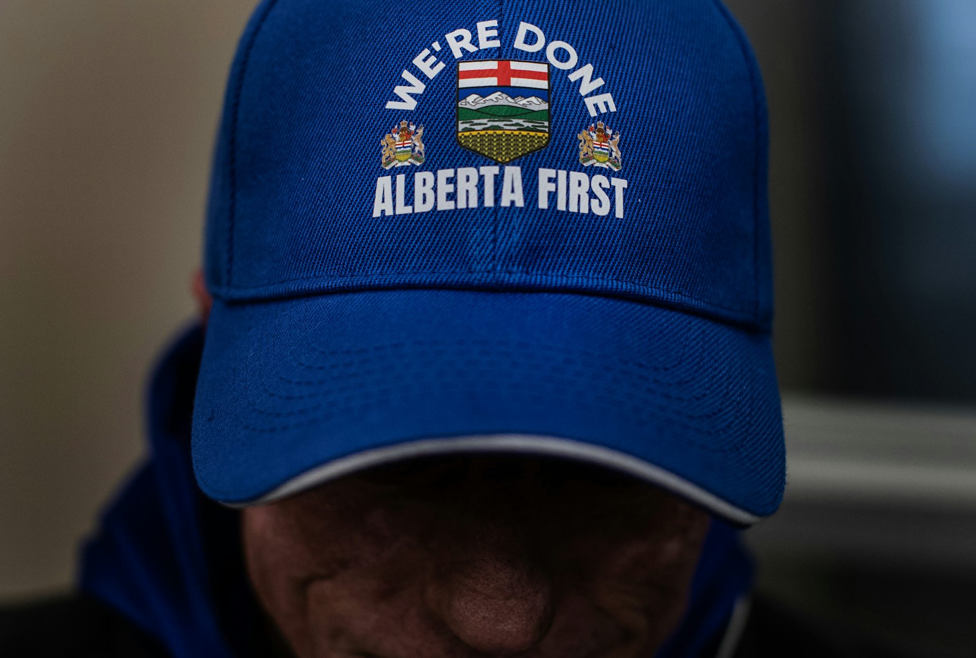 A person wearing an Alberta First ball cap.