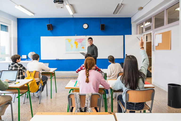 Un profesor junto a una pizarra en una clase