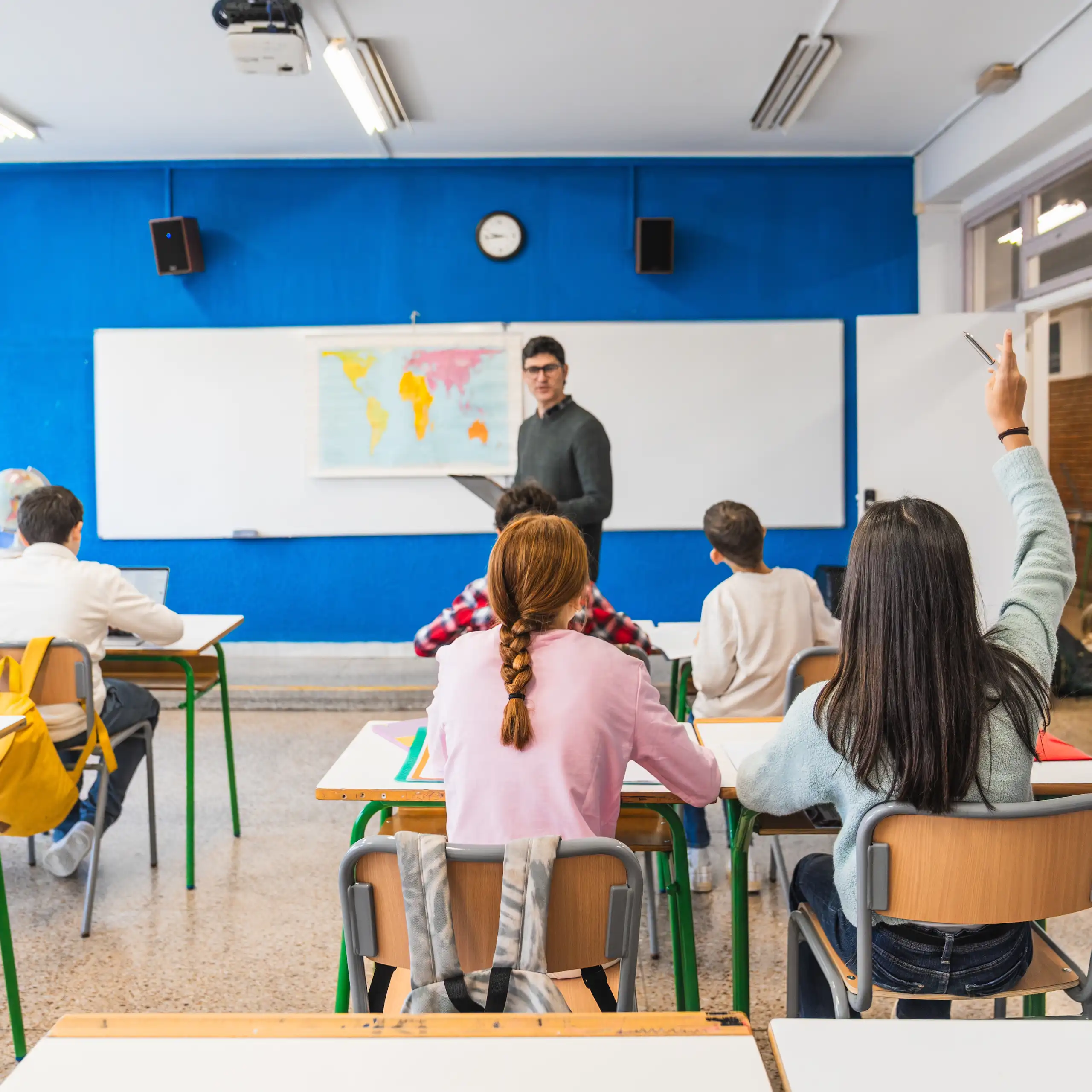 Un profesor junto a una pizarra en una clase