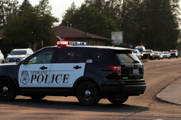 A police car with a long line of vehicles.
