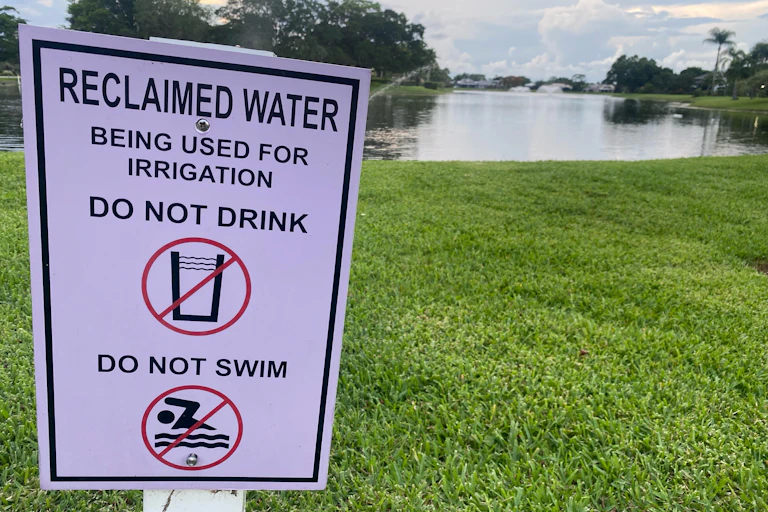 A sign reads 'reclaimed water being used for irrigation, do not drink or swim.'