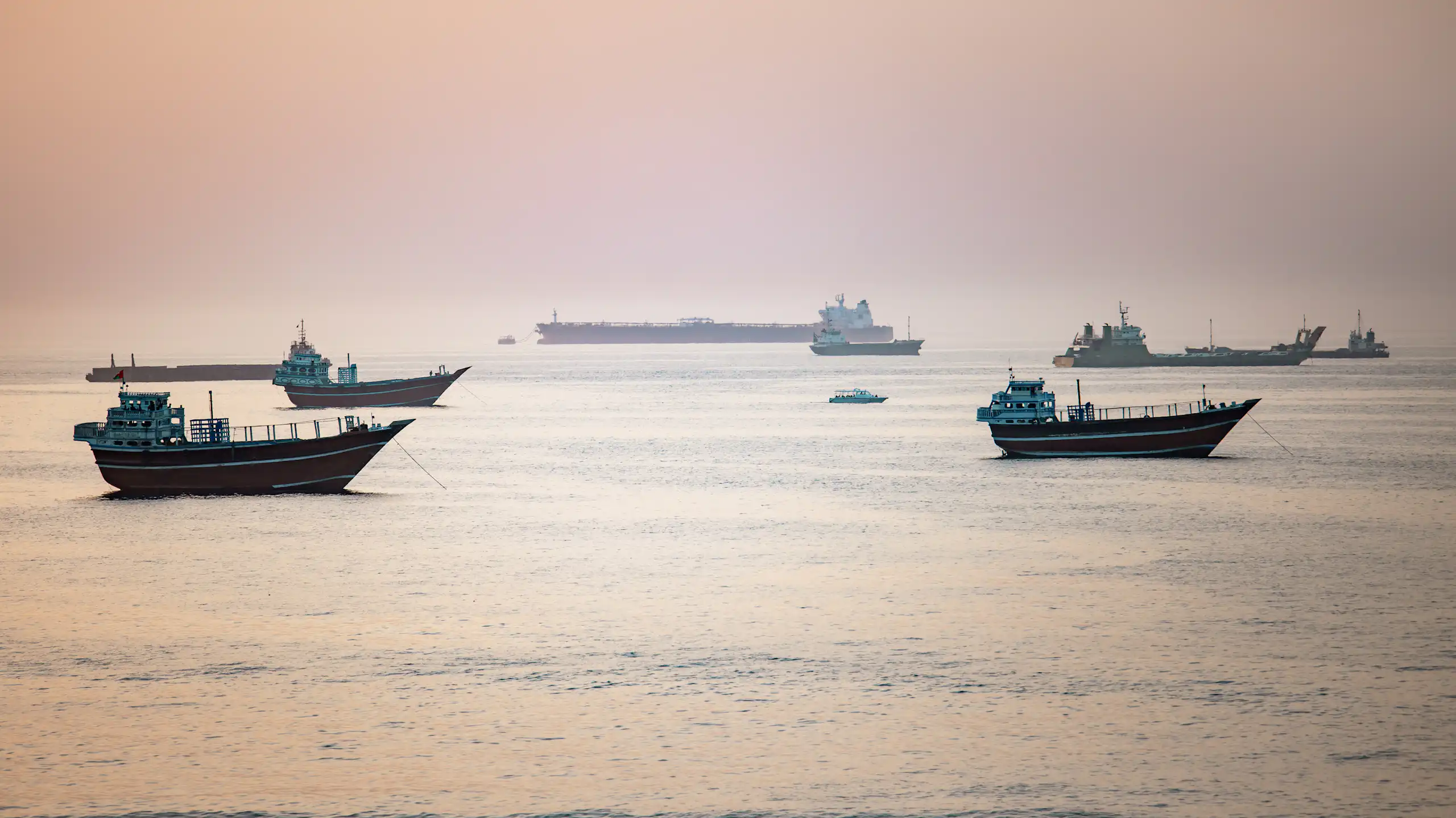 Crude oil tankers, bulk carriers and other vessels idle at anchor as they wait to pass the Strait of Hormuz.