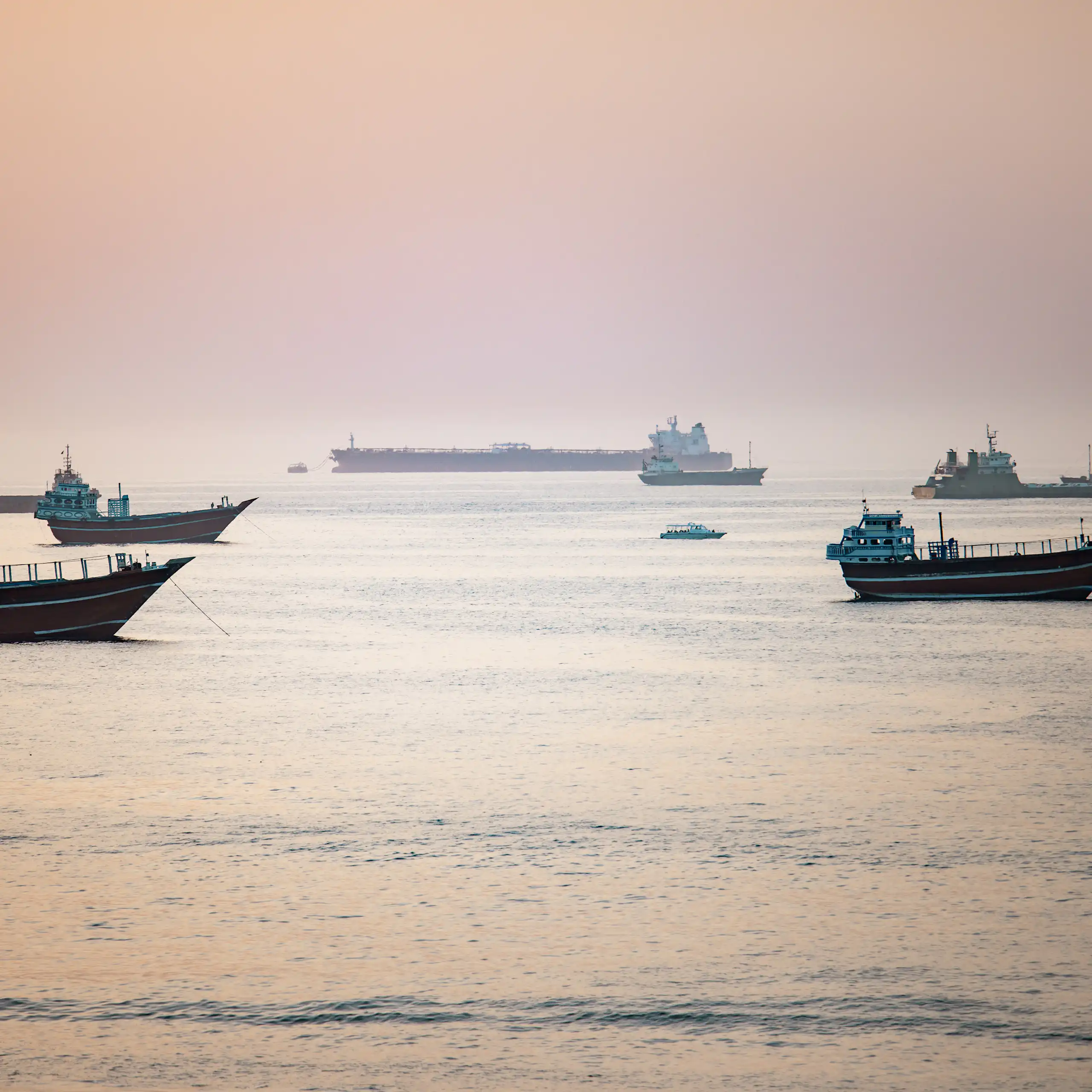 Crude oil tankers, bulk carriers and other vessels idle at anchor as they wait to pass the Strait of Hormuz.