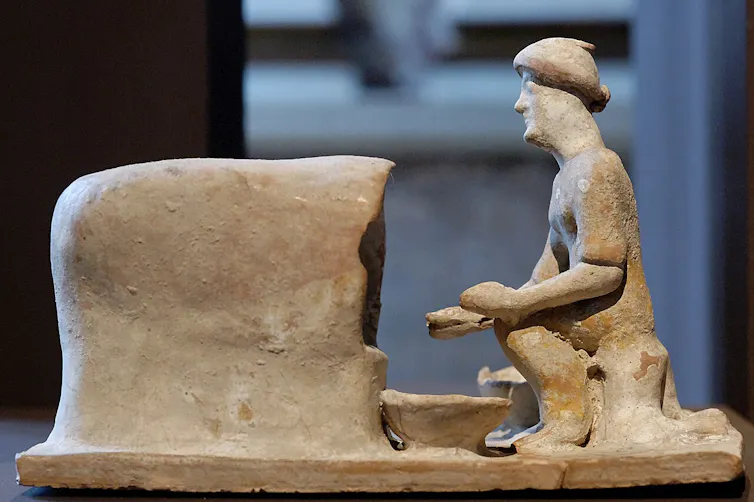 Terracotta figure of baker taking bread from oven