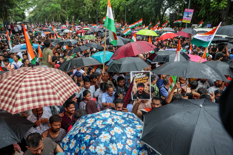 A crowod of people, many holding flags and umbrellas, march in Mumbai, July 25 2026.