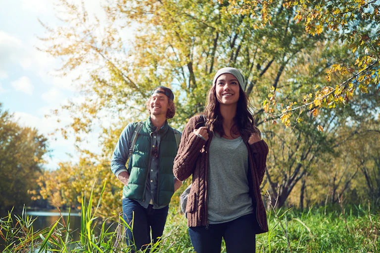 Un chico y una chica paseando por un bosque