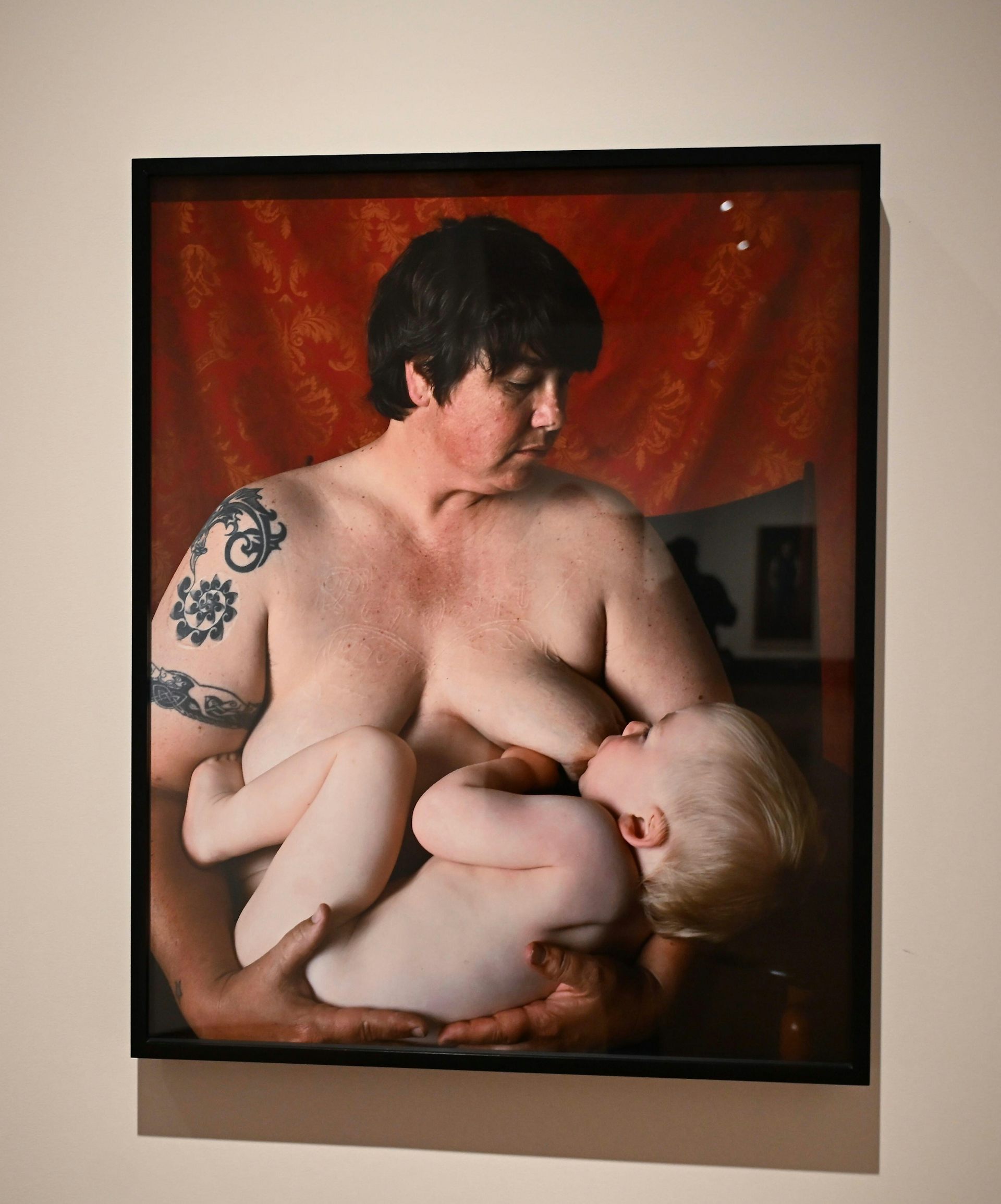 A photograph of a portrait of a woman breast-feeding her baby.