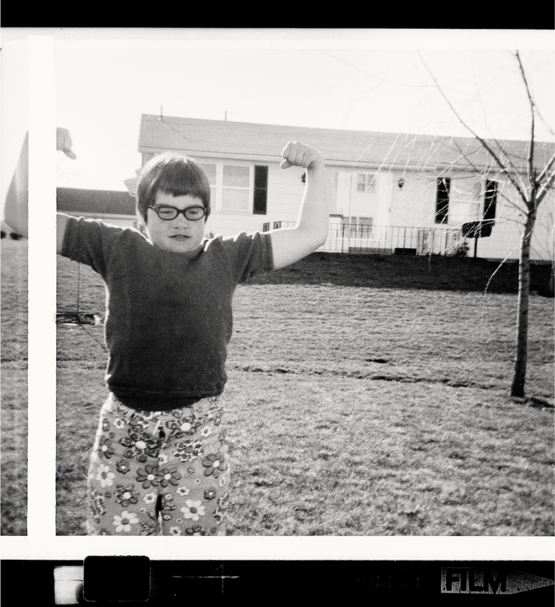 A black and white old fashioned images of a child in a bowl cut with specs and