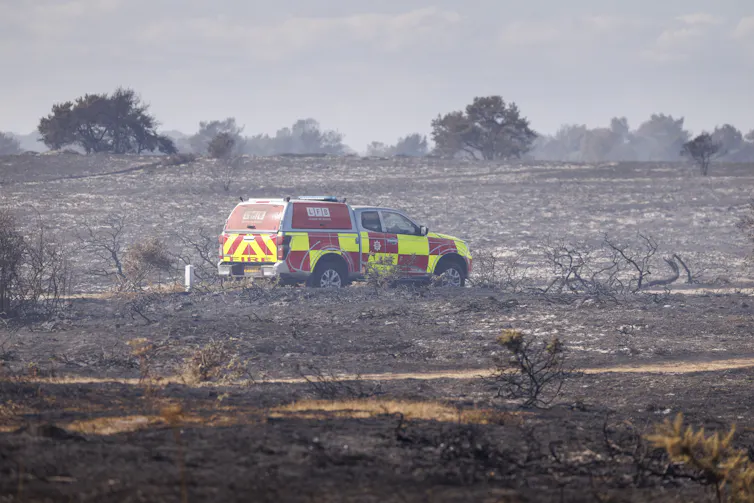 Firefighter car in burnt out wildfire aftermath