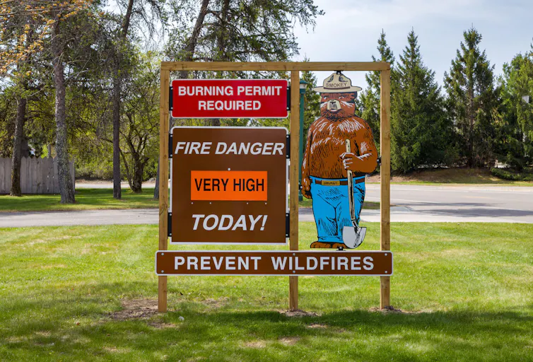 Smokey Bear with a fire danger warning sign