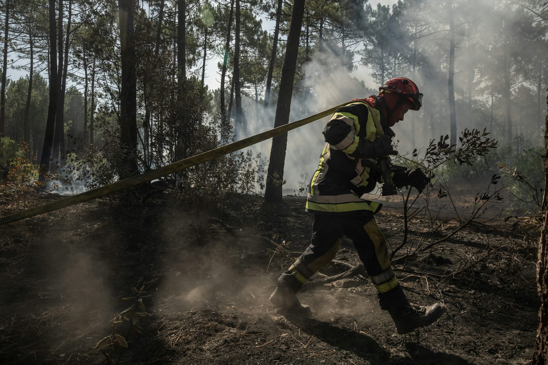 Un pompier s'efforce d'éteindre les flammes dans une forêt de Claouey, près de Lège-Cap-Ferret, le 28 juillet 2026.