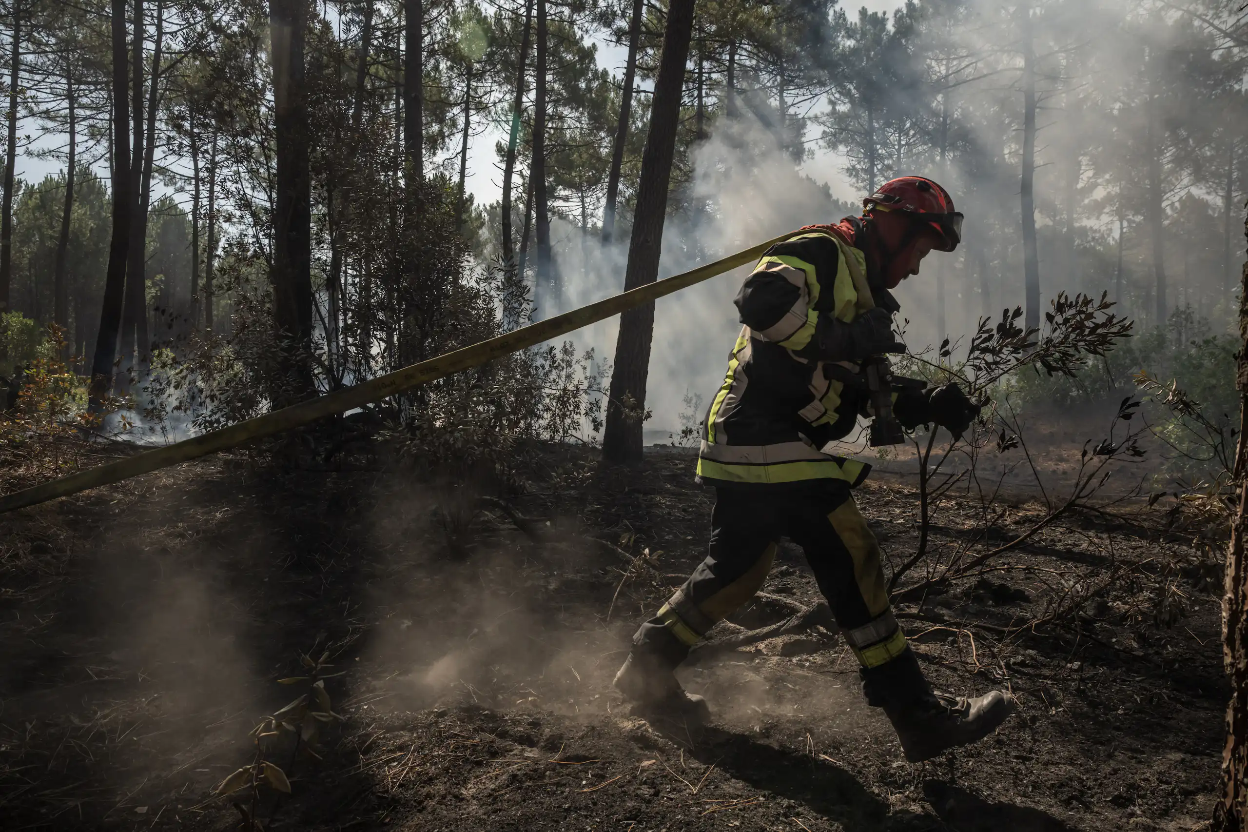 Un pompier s'efforce d'éteindre les flammes dans une forêt de Claouey, près de Lège-Cap-Ferret, le 28 juillet 2026.