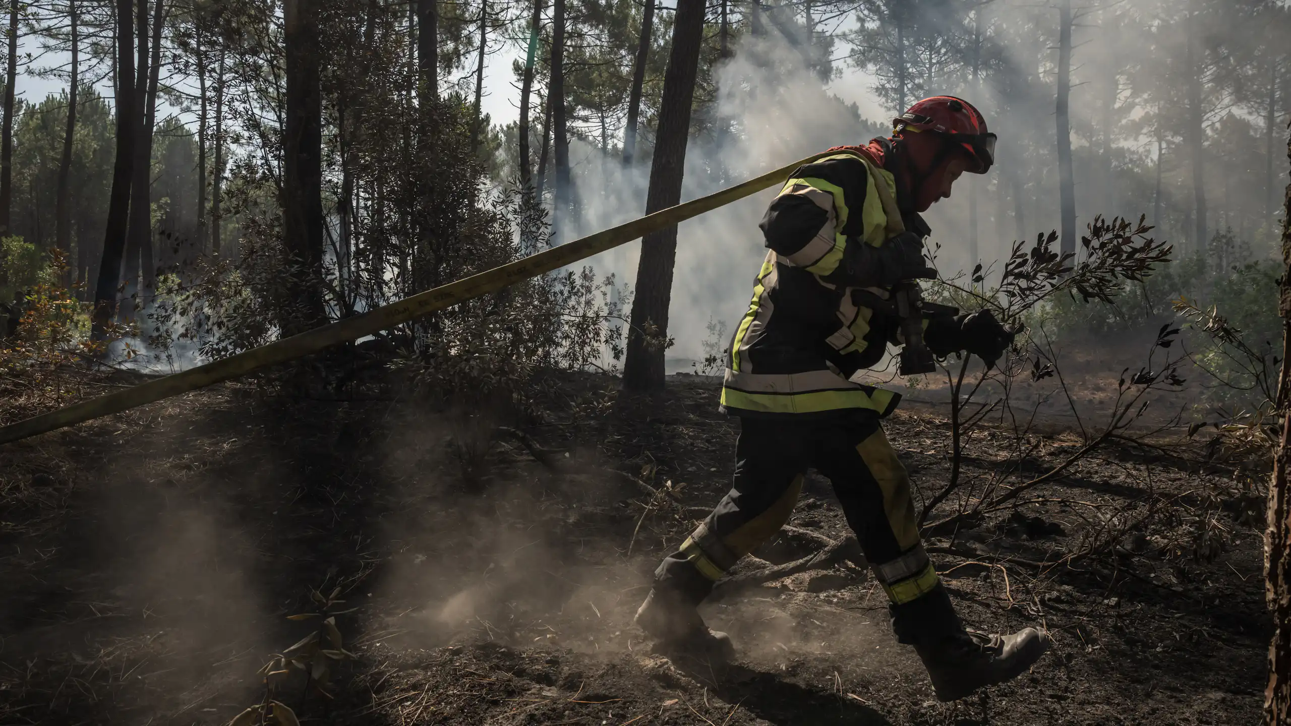 Un pompier s'efforce d'éteindre les flammes dans une forêt de Claouey, près de Lège-Cap-Ferret, le 28 juillet 2026.