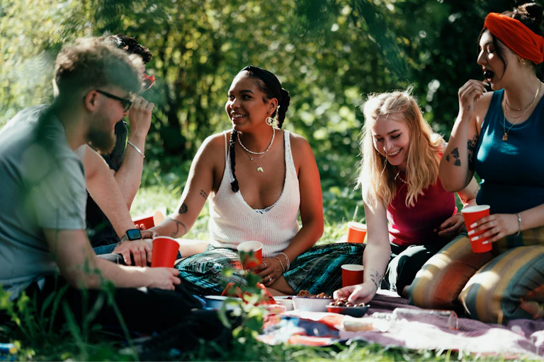 Young adults happily seated at a picnic
