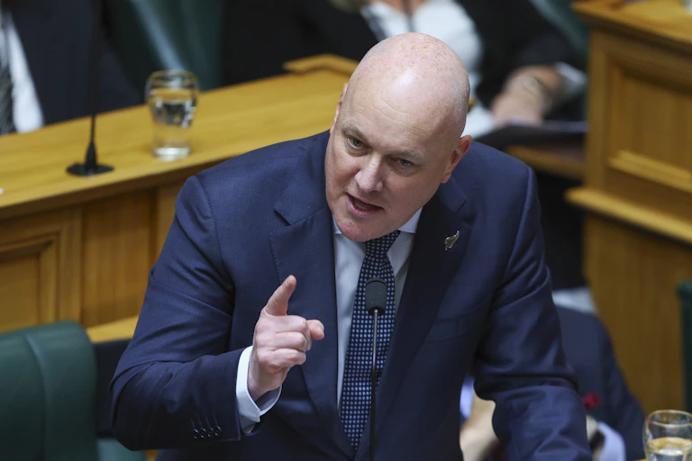 Christopher Luxon speaking in parliament and gesturing with hand