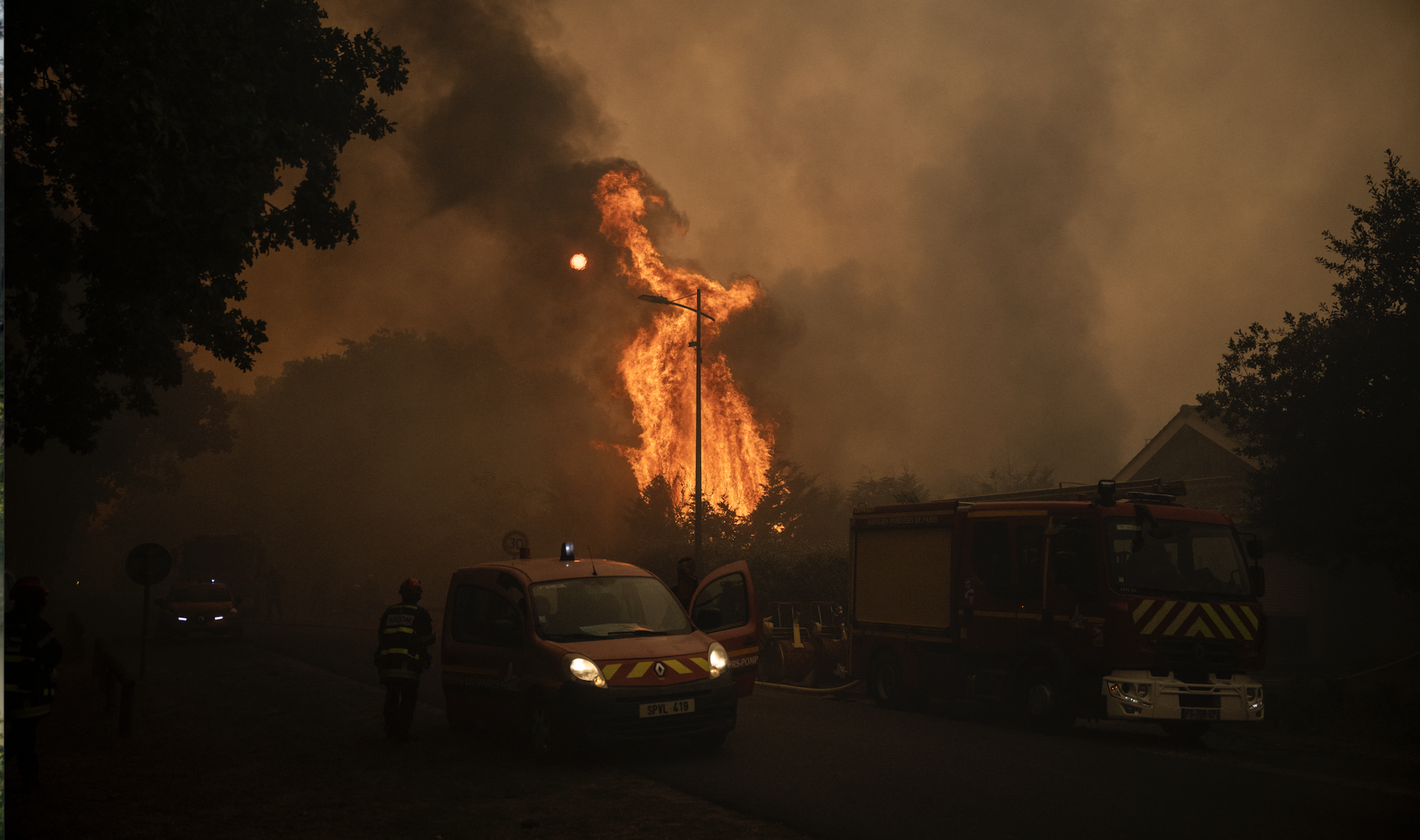 image d'une voiture de pompiers devant un feu de forêt