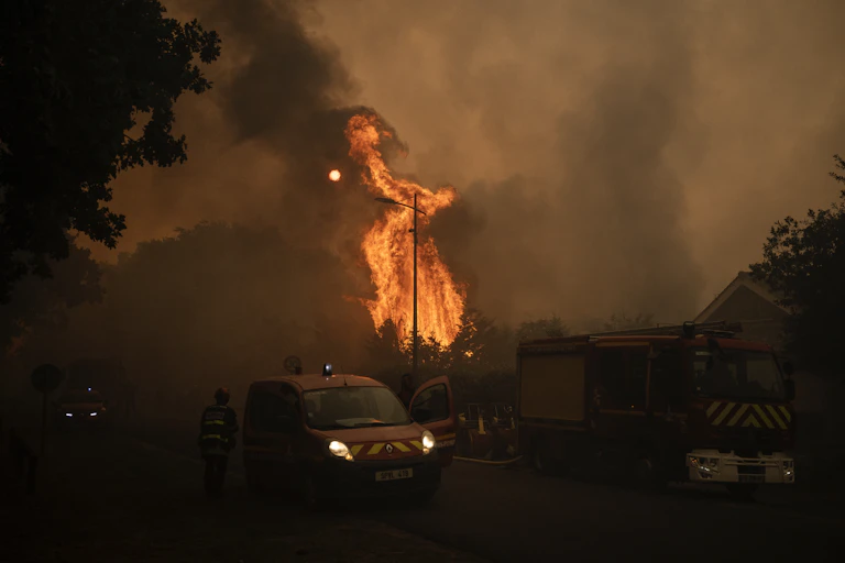 image d'une voiture de pompiers devant un feu de forêt