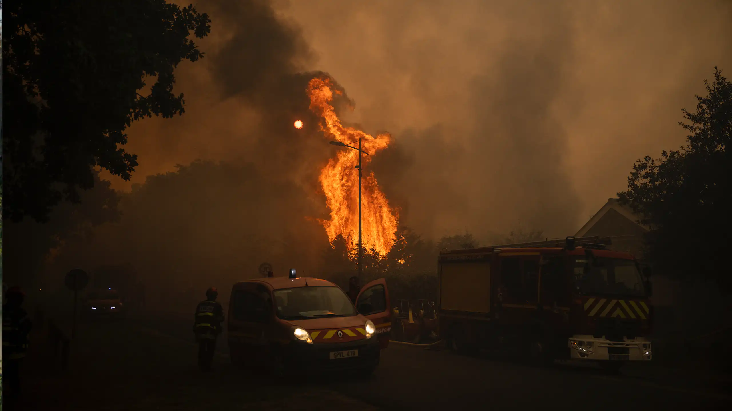 image d'une voiture de pompiers devant un feu de forêt
