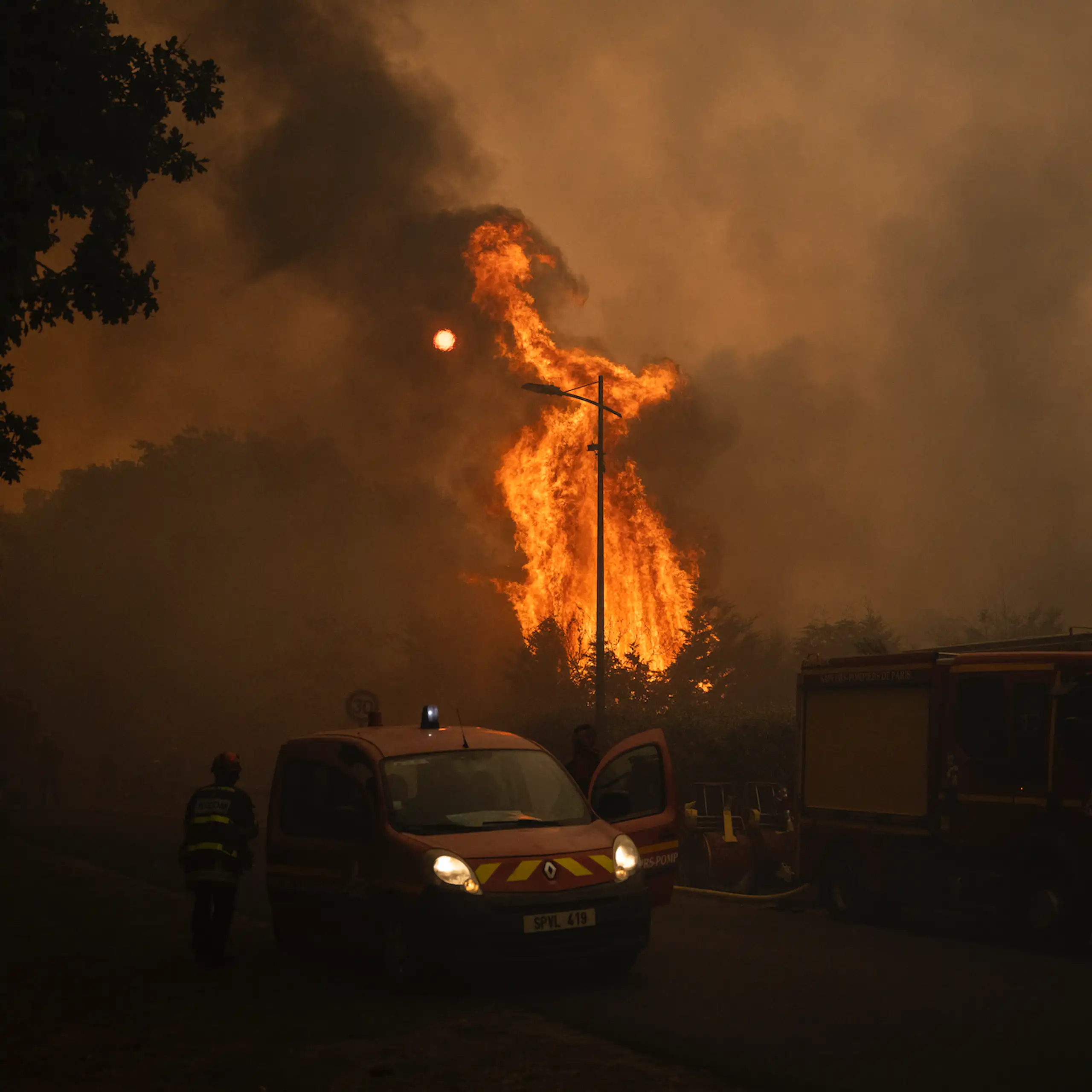 image d'une voiture de pompiers devant un feu de forêt