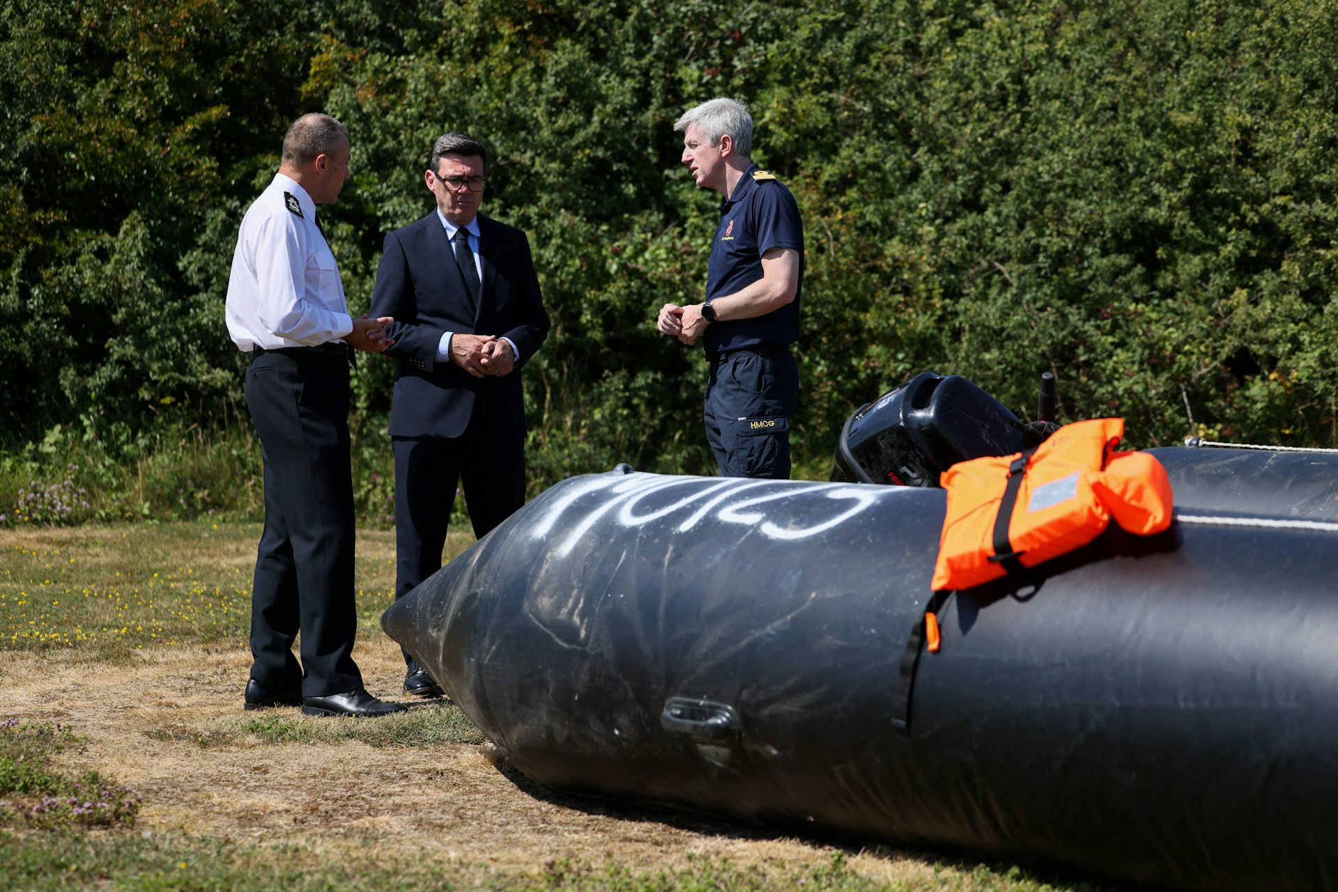 Andy Burnham and others looking at a small boat