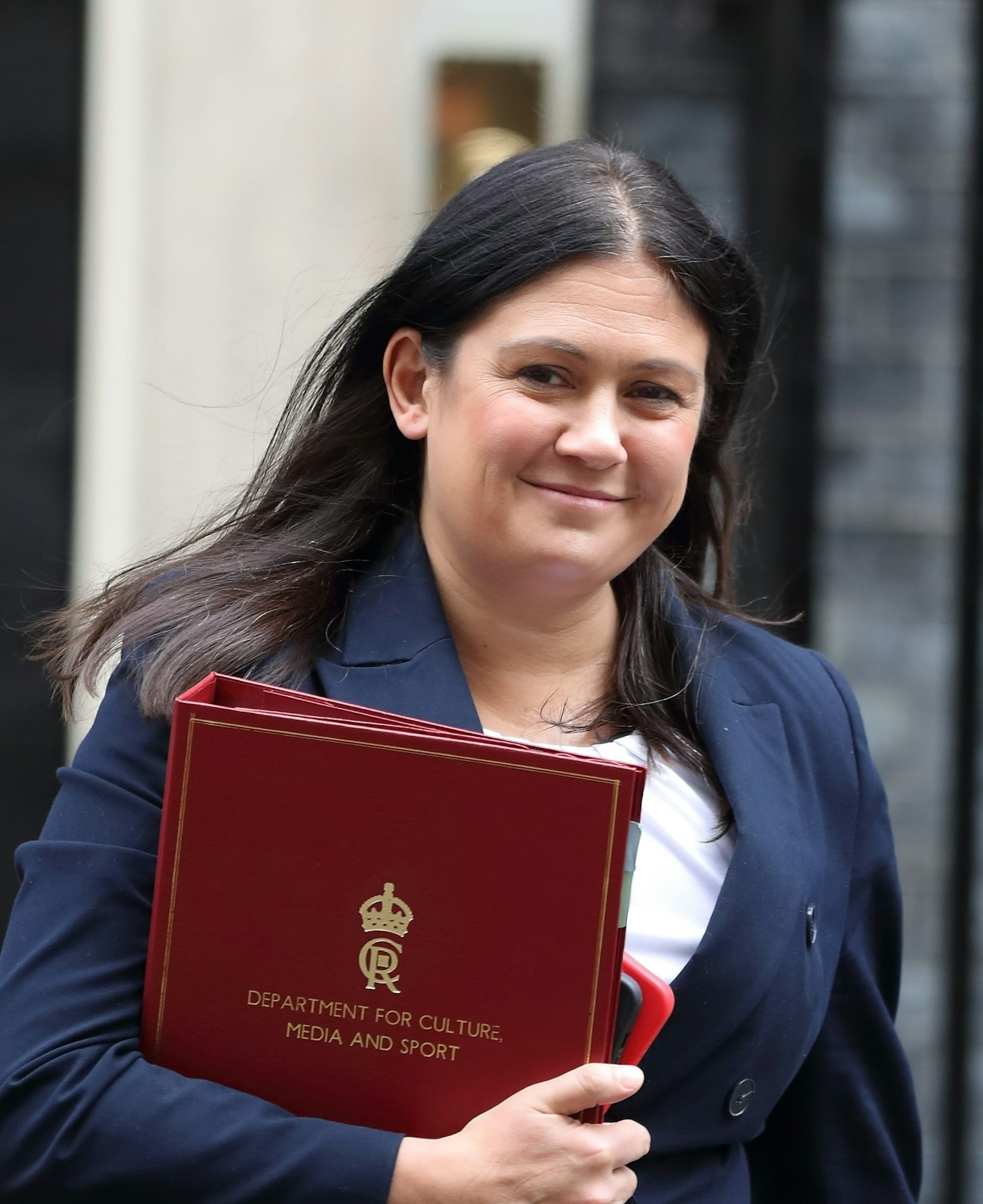 A woman with long dark hair outside number 10 Downing Street.