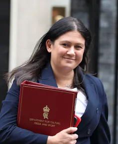 A woman with long dark hair outside number 10 Downing Street.