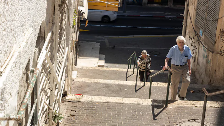 Two people climbing steep steps.