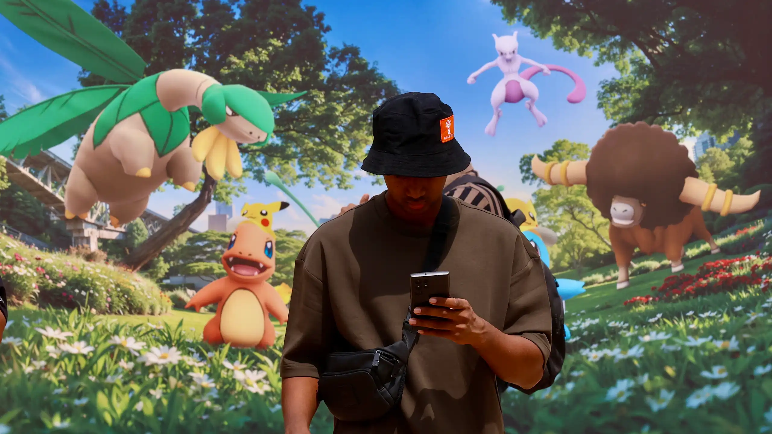 A gaming enthusiast plays Pokemon games on a mobile phone during Pokemon Go Fest 2026.