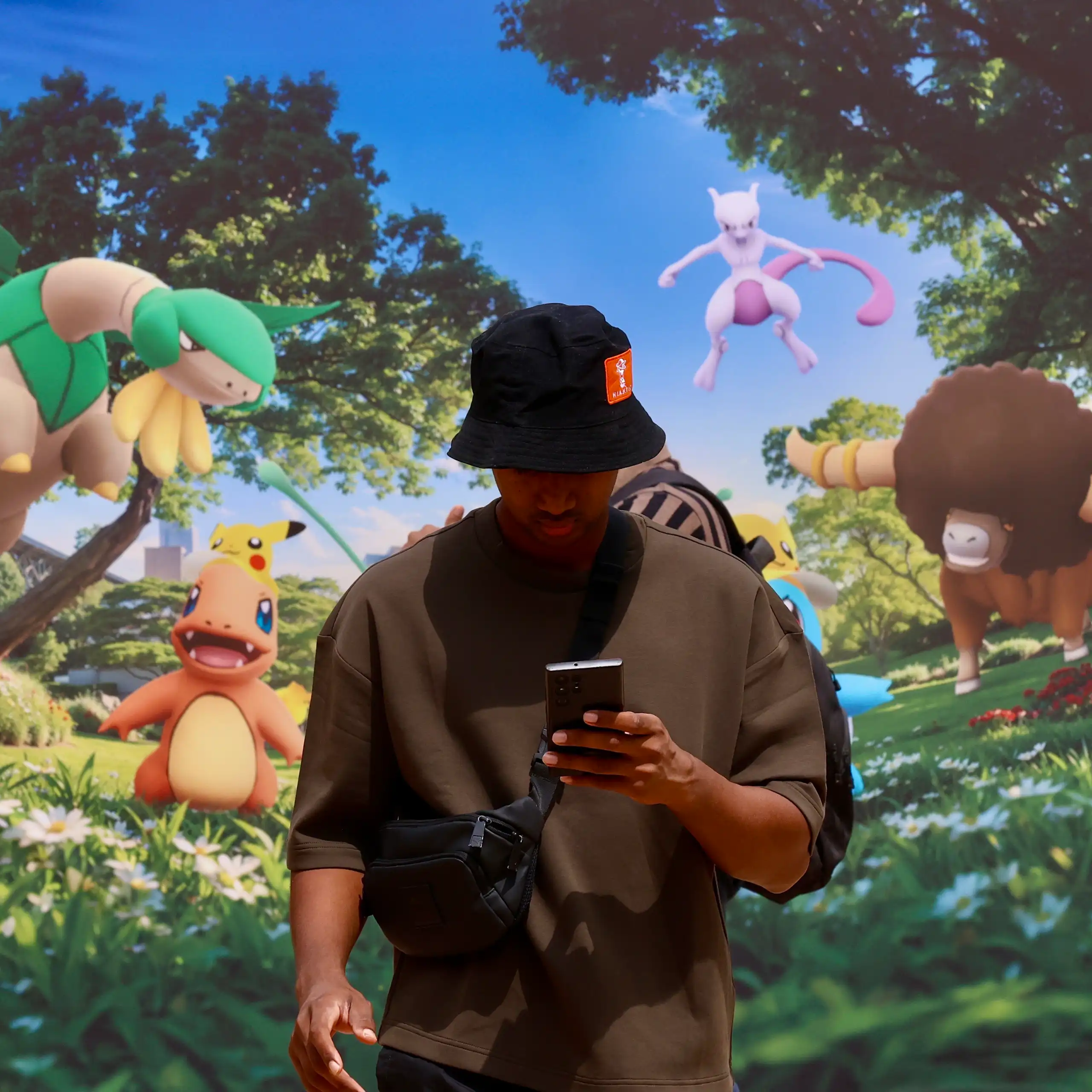 A gaming enthusiast plays Pokemon games on a mobile phone during Pokemon Go Fest 2026.