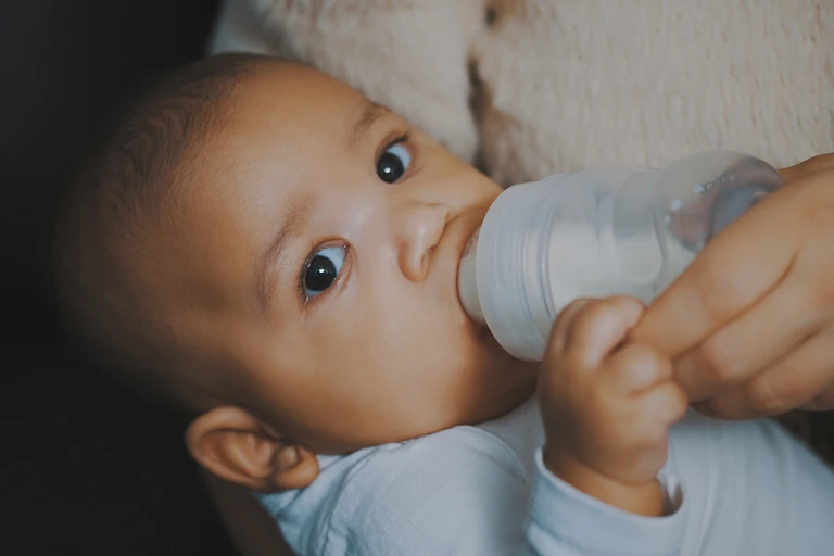 Baby being fed from bottle