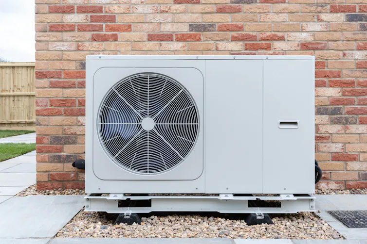 heat pump by brock wall outside of house