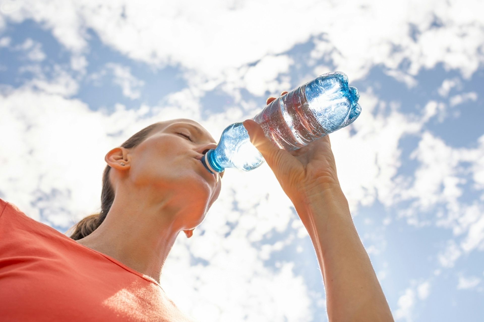 Woman drinking water from a bottle.
