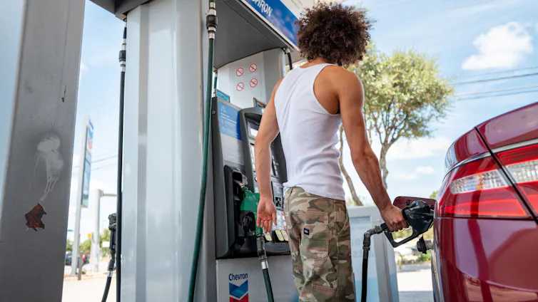 A person pumps gas into a car.