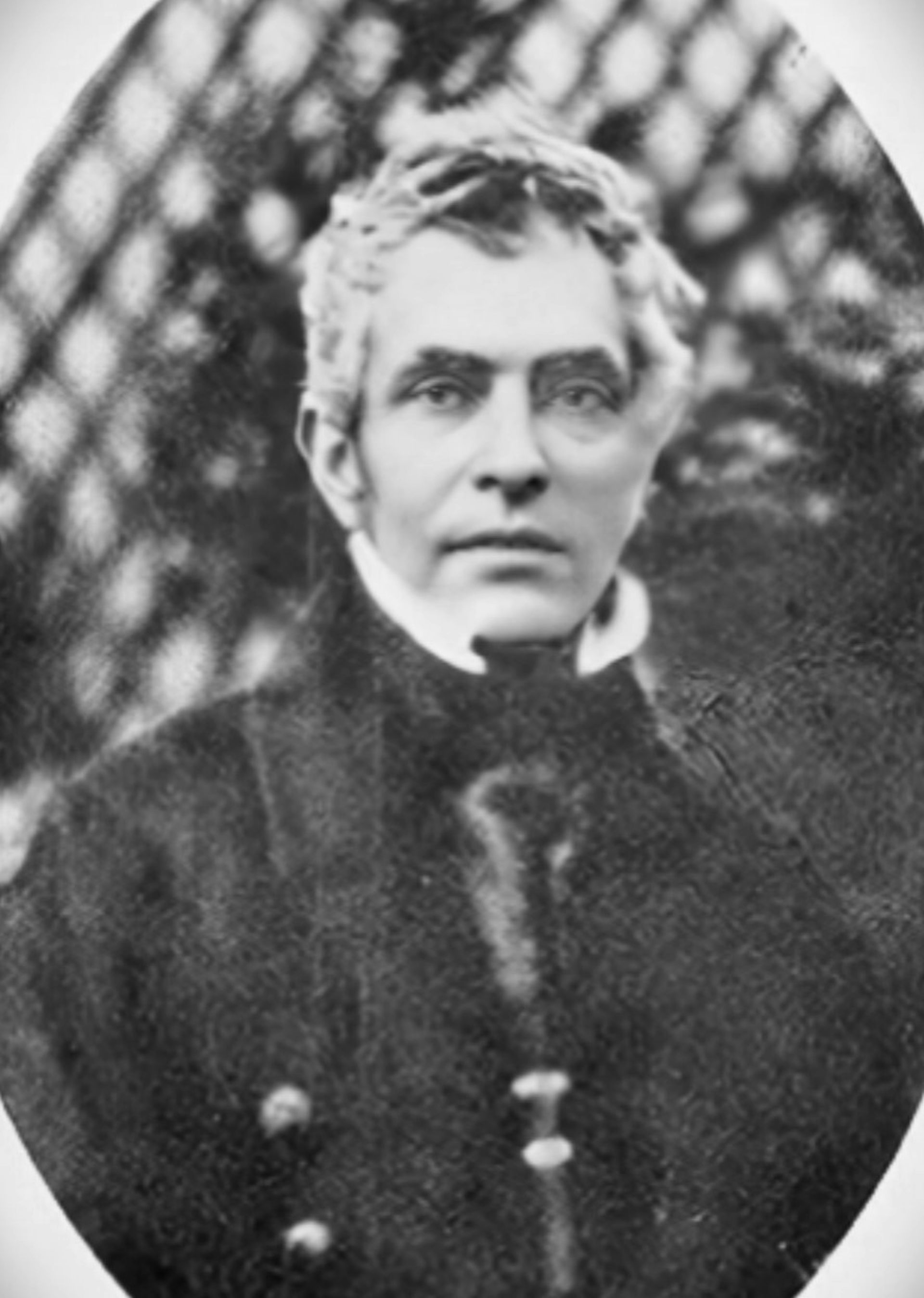 A black and white photo of a man with shaggy grey hair.