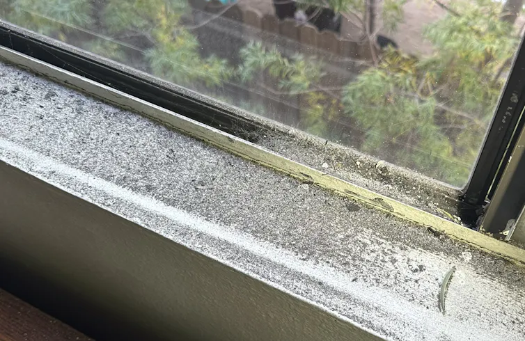 Dark ash or soot in a window sill.