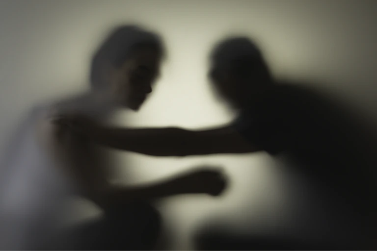 Blurred silhouette of two people tussling