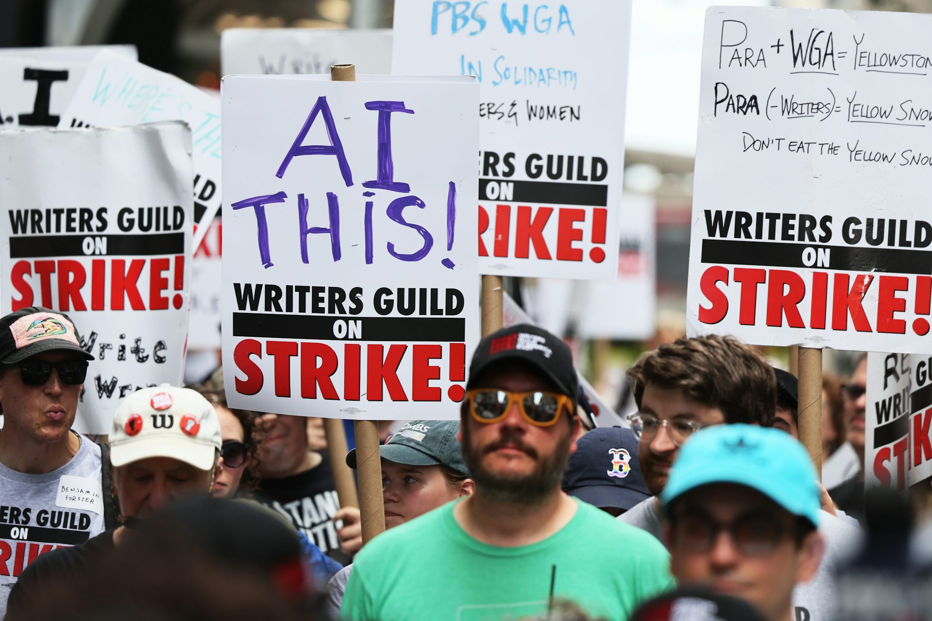 Striking members of the Writers Guild of America carry signs denouncing AI as they picket the New York office of Warner Bros. Discovery in July 2023.