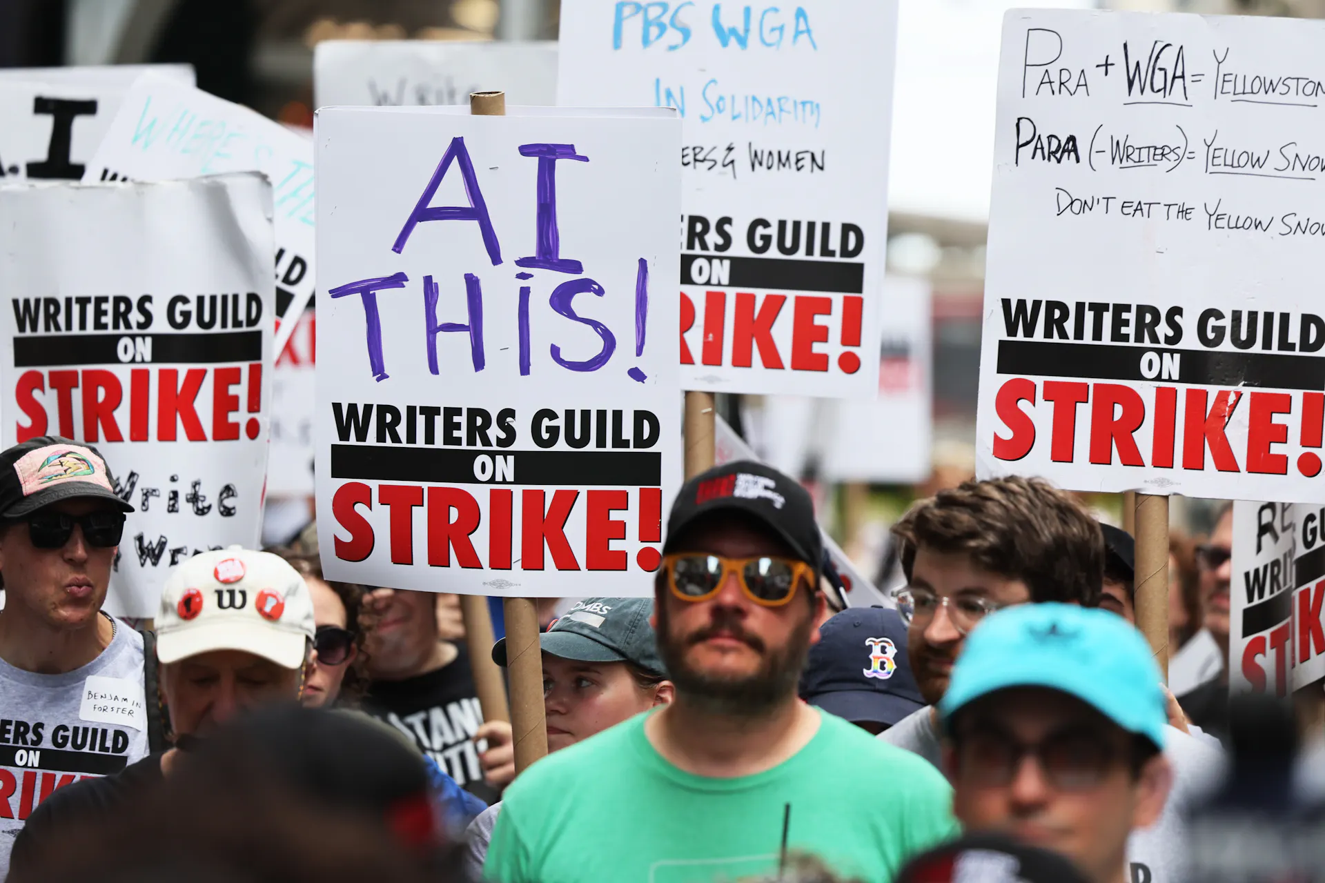 Striking members of the Writers Guild of America carry signs denouncing AI as they picket the New York office of Warner Bros. Discovery in July 2023.