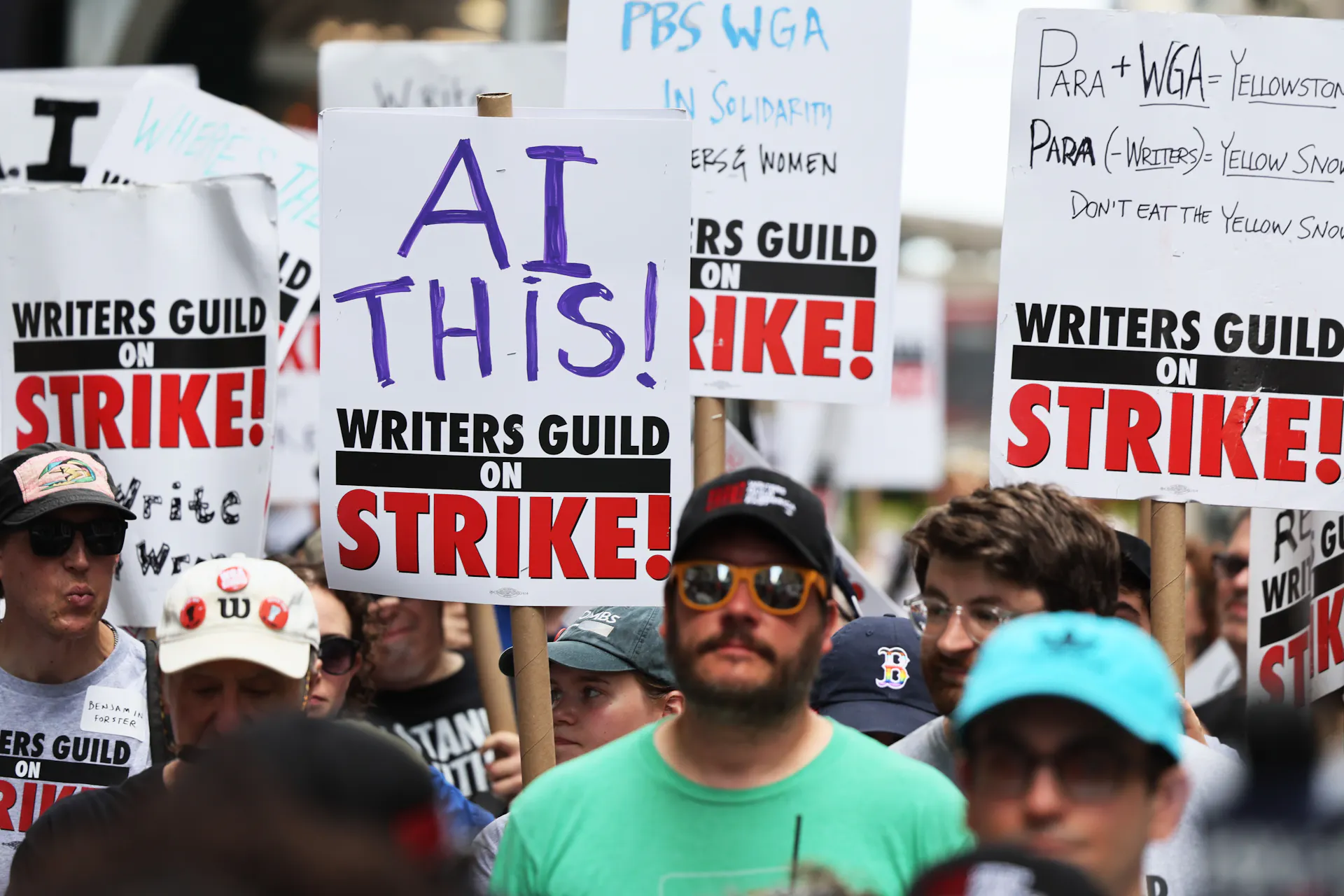 Striking members of the Writers Guild of America carry signs denouncing AI as they picket the New York office of Warner Bros. Discovery in July 2023.