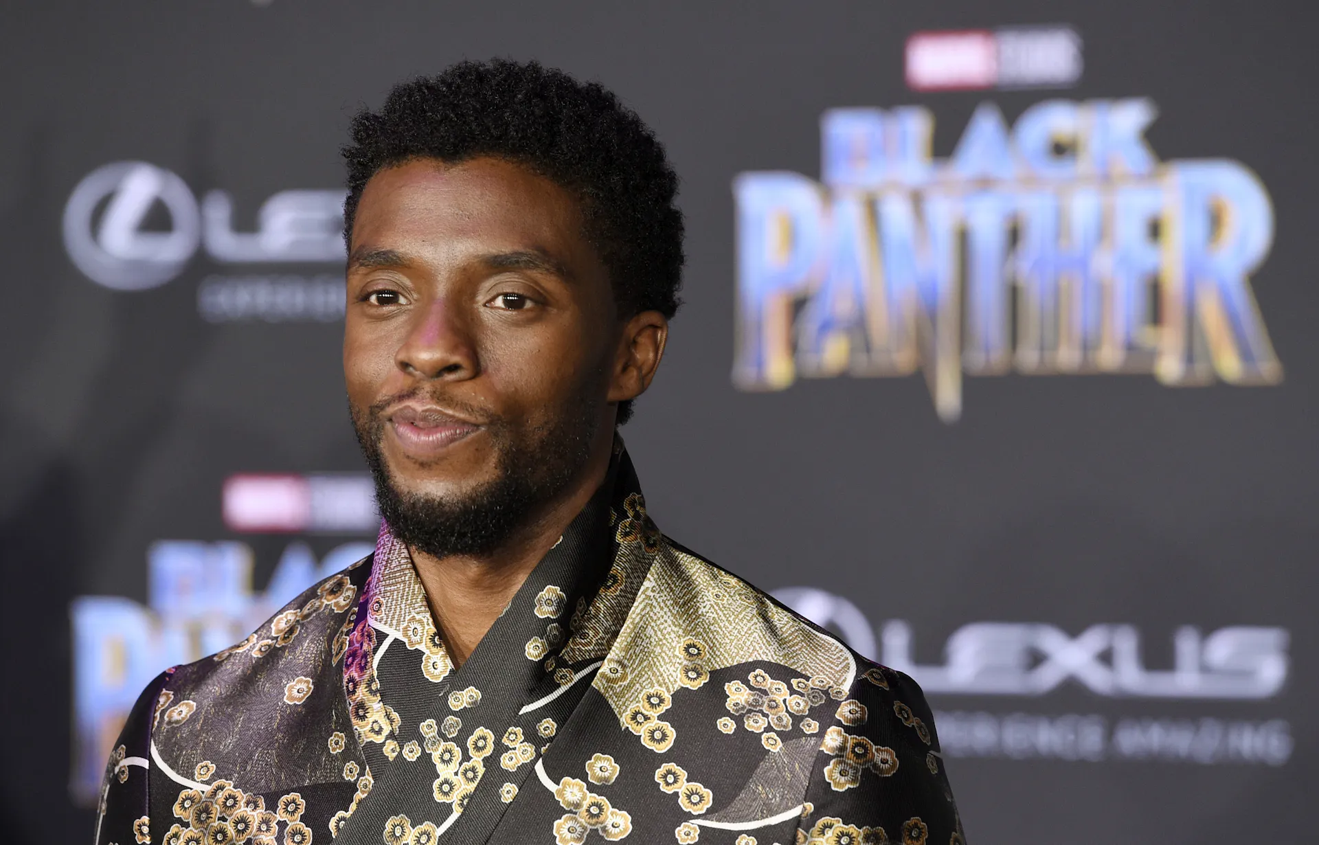 Headshot of Chadwick Boseman in front of Black Panther logo