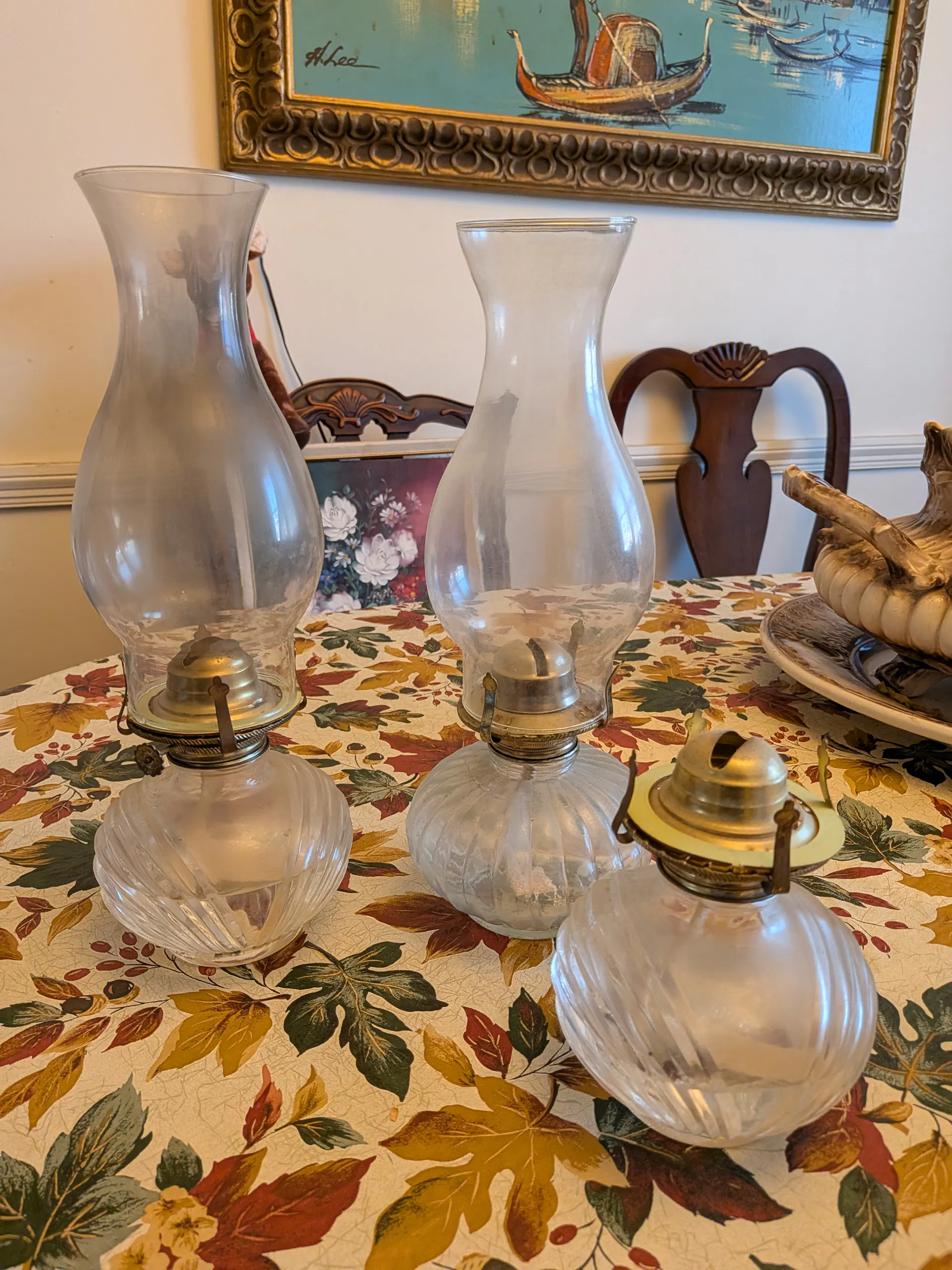 Three oil lamps sit on a table.