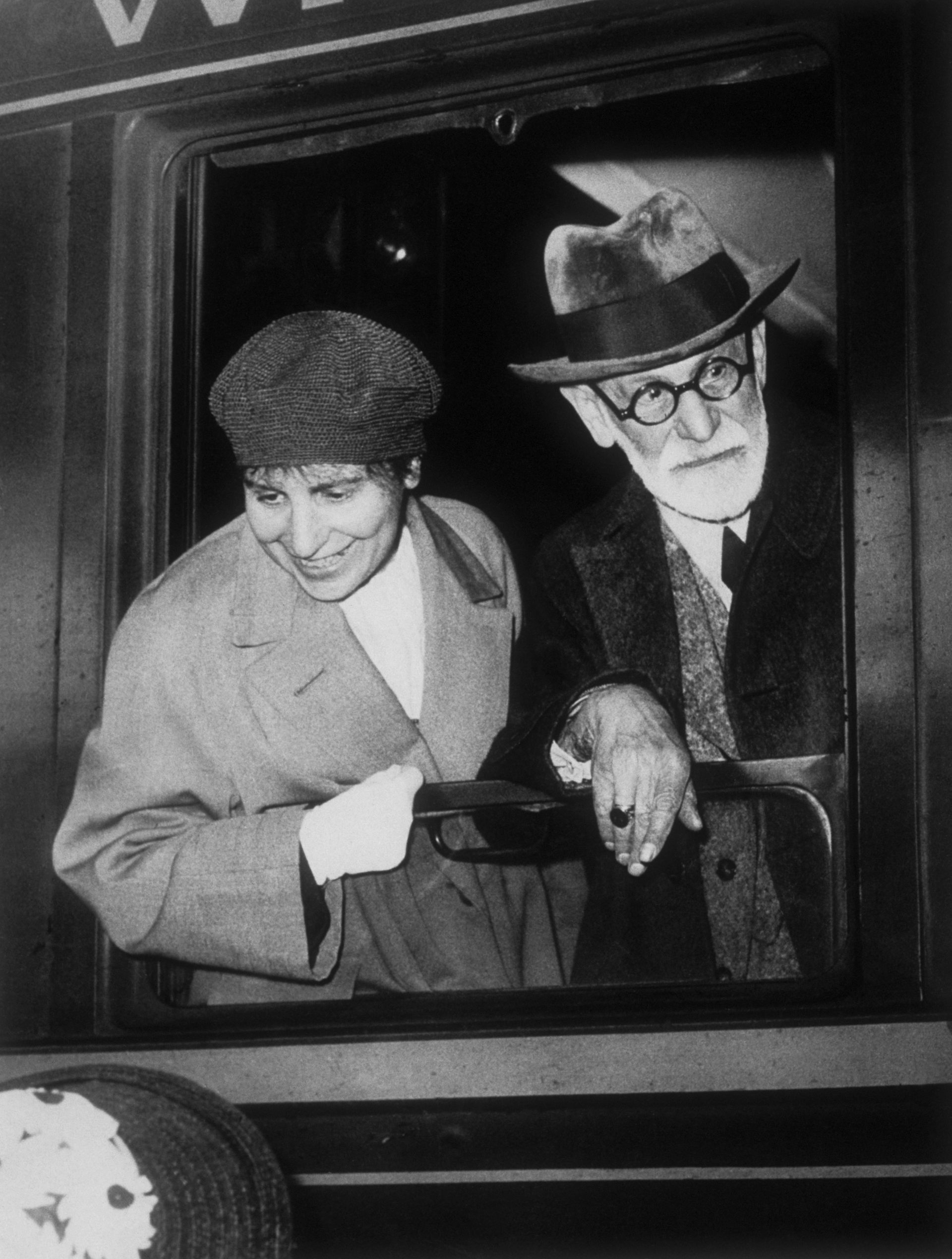 Sigmund Freud and Anna Freud lean out of a train window.