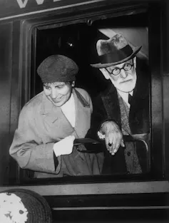 Sigmund Freud and Anna Freud lean out of a train window.